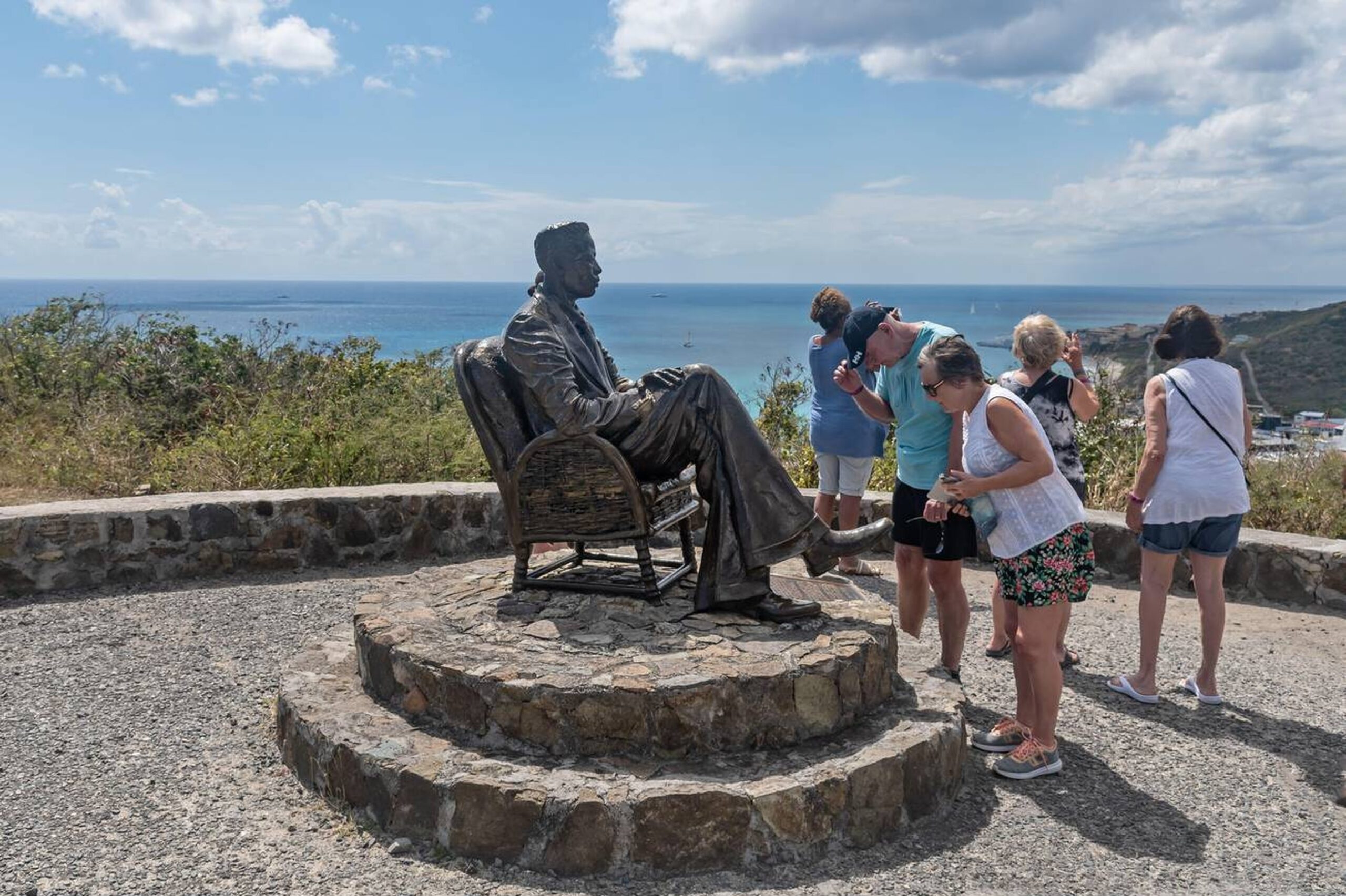 Tour group viewing a statue at a scenic lookout on St. Martin, part of the Circle Island Tour covering both sides of the island.