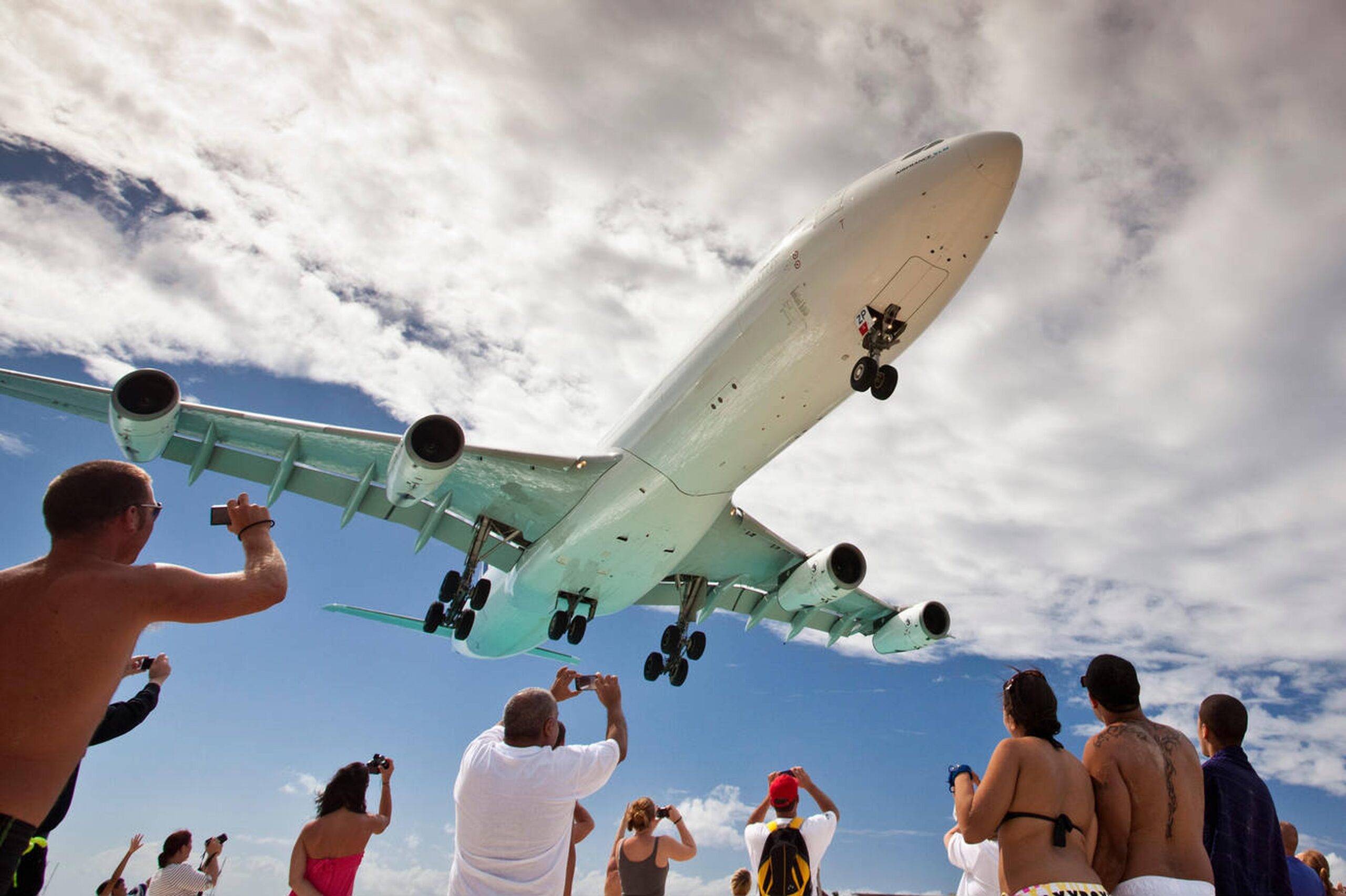 Low-flying airplane over Maho Beach in St. Maarten, symbolizing the Island Highlight Tour’s famous landmark stops.