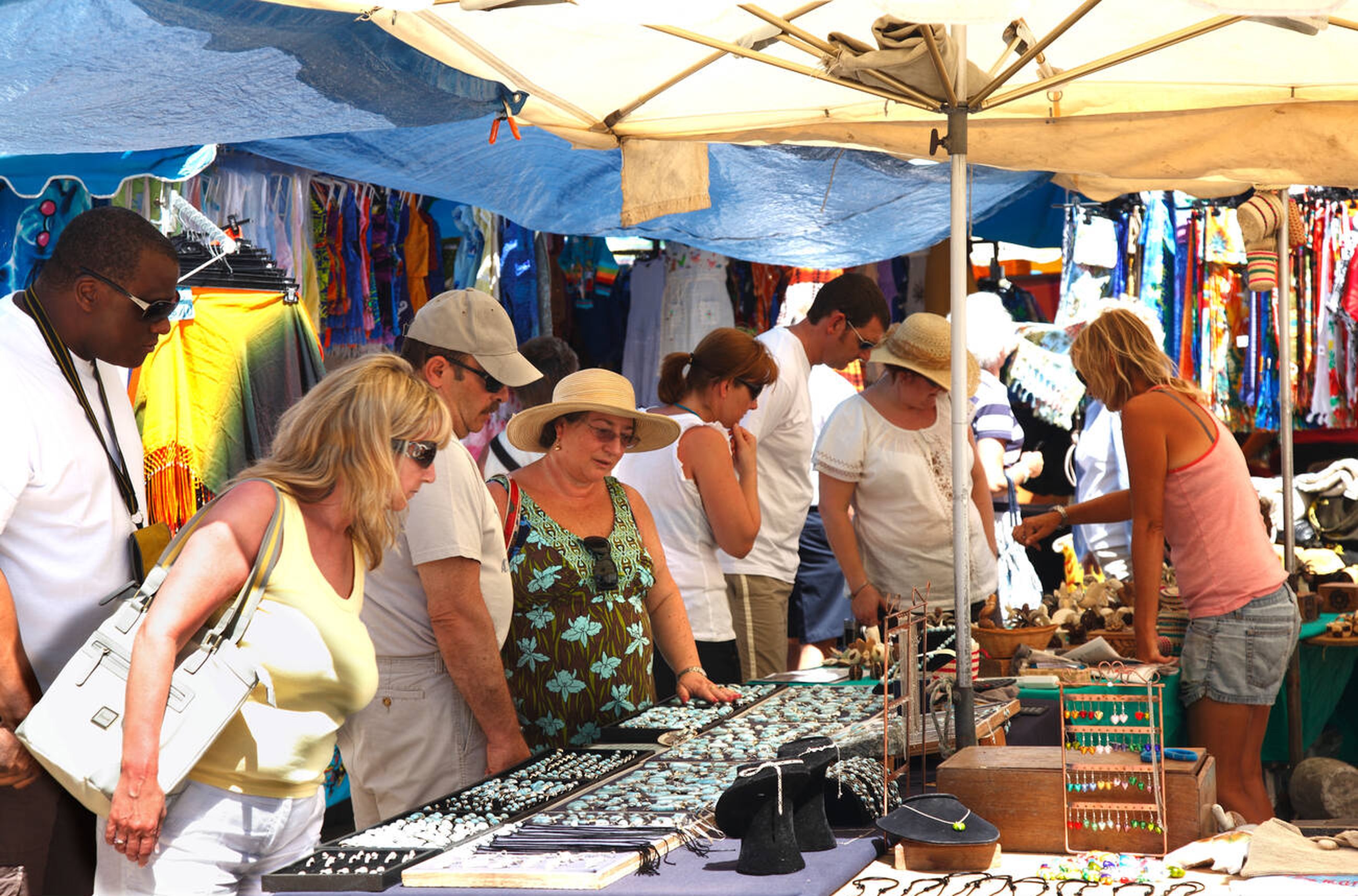 Group of travelers shopping at a local market in St. Maarten during the Jolly Group Tour experience.
